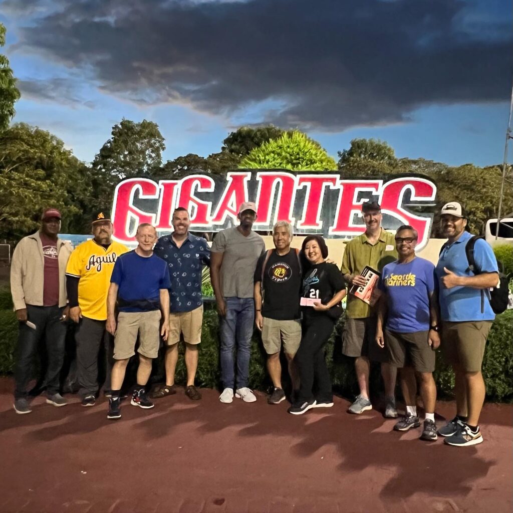 A tour group poses in front of the Gigantes logo.