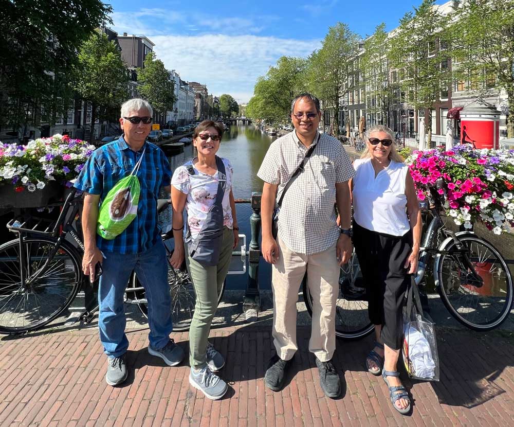 Tour guests stand in front of Amsterdam's canals